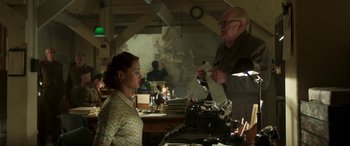 Movie still from “Churchill” (2017), directed by Jonathan Teplitzky – An older man and a young woman in front of a typewriter; Medium shot, Over the shoulder angle