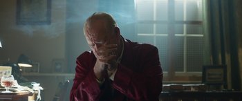 Movie still from “Churchill” (2017), directed by Jonathan Teplitzky – An older man in a red jacket is holding his hands to his face; Close Up shot, Low angle