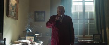 Movie still from “Churchill” (2017), directed by Jonathan Teplitzky – An older man in a robe drinking a glass of wine; Medium shot, Low angle
