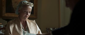 Movie still from “Churchill” (2017), directed by Jonathan Teplitzky – A woman sitting at a table looking at a book; Close Up shot, Low angle