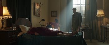 Movie still from “Churchill” (2017), directed by Jonathan Teplitzky – A person laying on a bed in a room; Wide shot, Low angle
