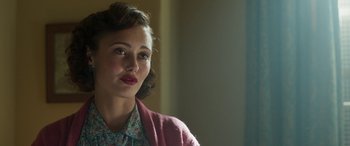 Movie still from “Churchill” (2017), directed by Jonathan Teplitzky – A young woman in a floral shirt and a pink sweater; Close Up shot, Over the shoulder angle