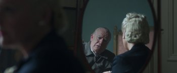 Movie still from “Churchill” (2017), directed by Jonathan Teplitzky – An older man sitting in front of a mirror; Close Up shot, Over the shoulder angle