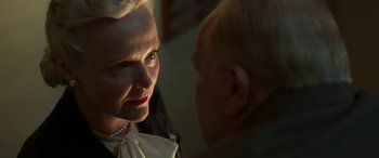 Movie still from “Churchill” (2017), directed by Jonathan Teplitzky – An older woman wearing a white shirt and a white bow tie; Close Up shot, Over the shoulder angle