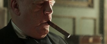Movie still from “Churchill” (2017), directed by Jonathan Teplitzky – A person smoking a cigar; Close Up shot, Low angle