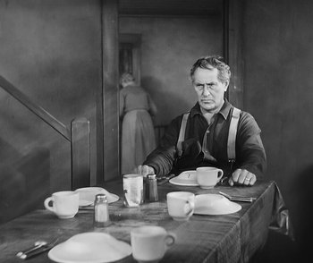 Movie still from “City Girl” (1930), directed by F.W. Murnau – An older man sitting at a table with plates and cups; Medium shot, High angle