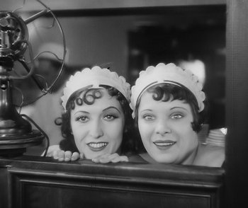 Movie still from “City Girl” (1930), directed by F.W. Murnau – A couple of women are posing for a picture; Medium shot, Low angle