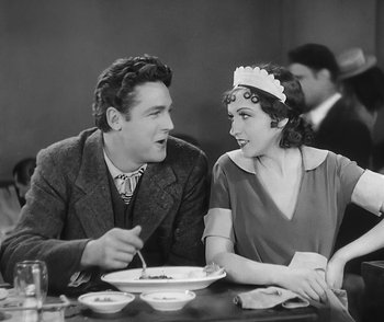 Movie still from “City Girl” (1930), directed by F.W. Murnau – A man and a woman sitting at a dinner table; Medium shot, Over the shoulder angle