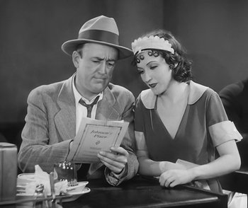 Movie still from “City Girl” (1930), directed by F.W. Murnau – An old photo of a man and a woman looking at a menu; Medium shot, High angle