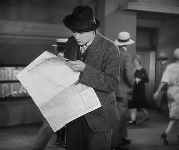 Movie still from “City Girl” (1930), directed by F.W. Murnau – A black and white photo of a man reading a newspaper; Medium shot, Low angle