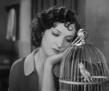 Movie still from “City Girl” (1930), directed by F.W. Murnau – An old photo of a woman looking at a birdcage; Close Up shot, High angle