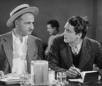 Movie still from “City Girl” (1930), directed by F.W. Murnau – Two men sitting at a table talking to each other; Medium shot, Over the shoulder angle