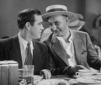 Movie still from “City Girl” (1930), directed by F.W. Murnau – A couple of men sitting at a dinner table talking to each other; Medium shot, Over the shoulder angle