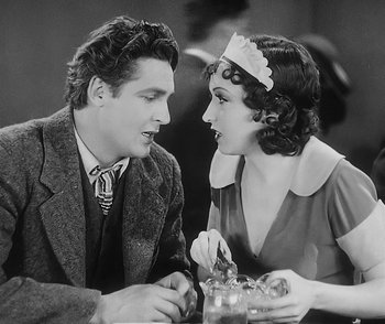 Movie still from “City Girl” (1930), directed by F.W. Murnau – A man and a woman sitting at a table talking to each other; Medium shot, High angle
