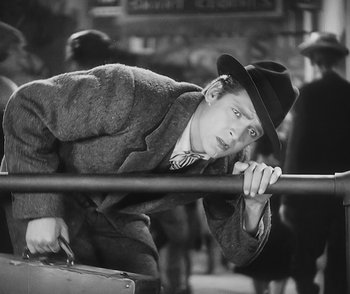 Movie still from “City Girl” (1930), directed by F.W. Murnau – A man in a hat leaning over a railing with a briefcase; Medium shot, Low angle