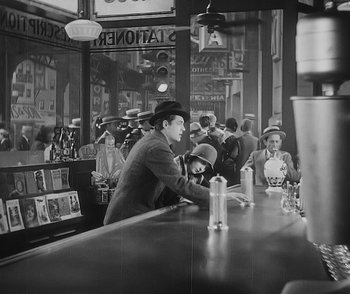 Movie still from “City Girl” (1930), directed by F.W. Murnau – A man sitting at the bar of a restaurant with other patrons; Wide shot, High angle