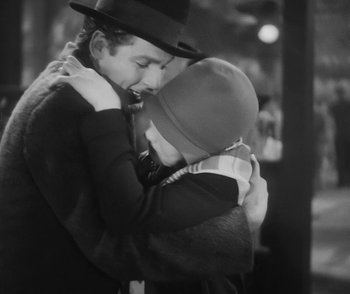 Movie still from “City Girl” (1930), directed by F.W. Murnau – A man and a woman hugging each other in front of a building; Close Up shot, High angle