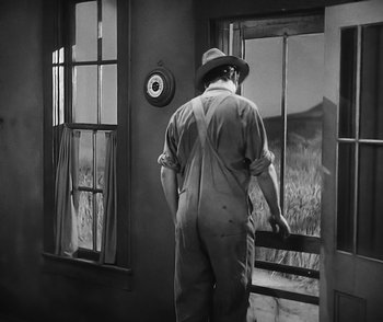 Movie still from “City Girl” (1930), directed by F.W. Murnau – A man standing in front of an open window; Medium shot, High angle