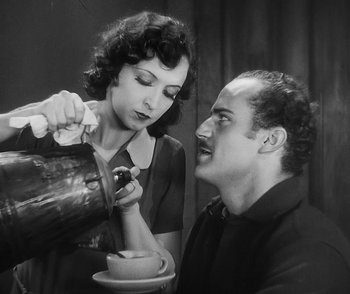 Movie still from “City Girl” (1930), directed by F.W. Murnau – An old photo of a man and a woman pouring wine; Medium shot, High angle