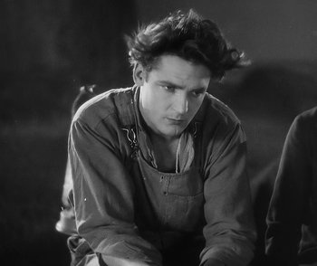 Movie still from “City Girl” (1930), directed by F.W. Murnau – Black and white photograph of a young man sitting in a chair; Close Up shot, Low angle