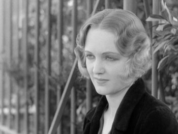 Movie still from “City Lights” (1931), directed by Charles Chaplin – A black and white photo of a woman in a black jacket; Close Up shot, High angle
