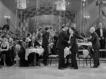 Movie still from “City Lights” (1931), directed by Charles Chaplin – A black and white photo of people dancing at a party; Wide shot, High angle