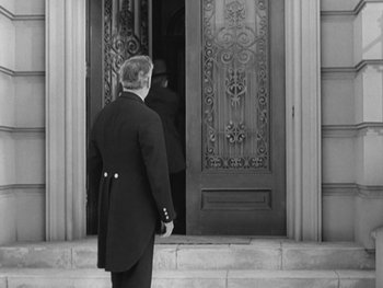 Movie still from “City Lights” (1931), directed by Charles Chaplin – A black and white photo of a man in a uniform; Medium shot, Low angle