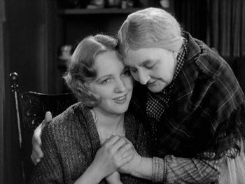 Movie still from “City Lights” (1931), directed by Charles Chaplin – An older woman hugging a younger woman while sitting on a chair; Close Up shot, High angle