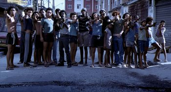 Movie still from “City of God” (2002), directed by Kátia Lund – A group of people standing on the side of the street; Wide shot, High angle