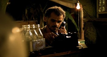 Movie still from “City of God” (2002), directed by Kátia Lund – A man on the phone looking at a camera; Close Up shot, Low angle