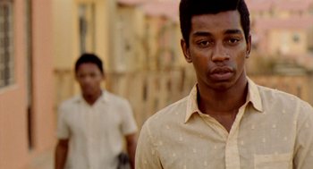 Movie still from “City of God” (2002), directed by Kátia Lund – Two young men walking down a street in a city; Close Up shot, Over the shoulder angle