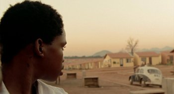 Movie still from “City of God” (2002), directed by Kátia Lund – A young boy is looking out at the sky; Close Up shot, Over the shoulder angle