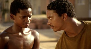 Movie still from “City of God” (2002), directed by Kátia Lund – Two young men talking to each other outside; Close Up shot, Over the shoulder angle
