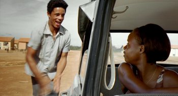 Movie still from “City of God” (2002), directed by Kátia Lund – A young man and a little girl sitting in the back of a car; Medium shot, Over the shoulder angle