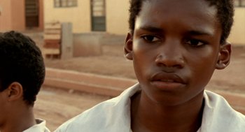 Movie still from “City of God” (2002), directed by Kátia Lund – A person wearing a white shirt; Close Up shot, Low angle