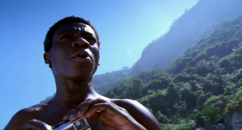 Movie still from “City of God” (2002), directed by Kátia Lund – A man holding a camera in front of a lush green hillside; Extreme Close Up shot, Low angle