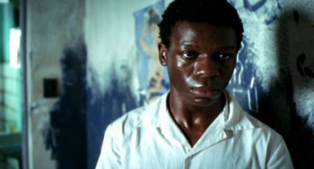 Movie still from “City of God” (2002), directed by Kátia Lund – A young man in a white shirt is looking at the camera; Close Up shot, Low angle