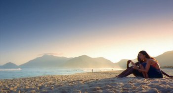 Movie still from “City of God” (2002), directed by Kátia Lund – A person sitting on the beach in front of the ocean; Extreme Wide shot, Low angle