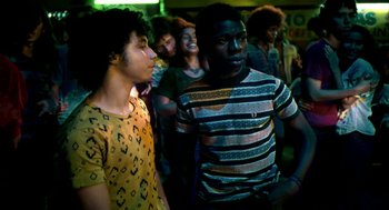 Movie still from “City of God” (2002), directed by Kátia Lund – A group of young men standing next to each other in a room; Medium shot, Over the shoulder angle