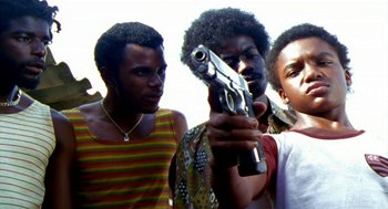 Movie still from “City of God” (2002), directed by Kátia Lund – A group of young men standing next to each other holding guns; Medium shot, Low angle