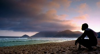 Movie still from “City of God” (2002), directed by Kátia Lund – A person standing on a beach near the ocean; Extreme Wide shot, Low angle
