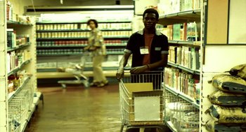 Movie still from “City of God” (2002), directed by Kátia Lund – A man pushing a shopping cart in a grocery store; Medium shot, Over the shoulder angle