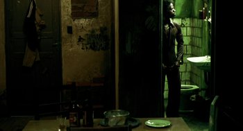 Movie still from “City of God” (2002), directed by Kátia Lund – A man standing in front of a mirror in a room; Wide shot, Low angle