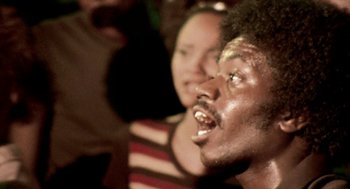 Movie still from “City of God” (2002), directed by Kátia Lund – A man and a woman in a crowd of onlookers; Close Up shot, Low angle