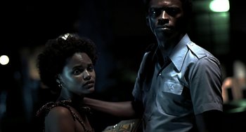 Movie still from “City of God” (2002), directed by Kátia Lund – A man and a woman standing next to each other in the dark; Close Up shot, Low angle