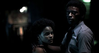 Movie still from “City of God” (2002), directed by Kátia Lund – A man and a woman standing next to each other in the dark; Close Up shot, Low angle