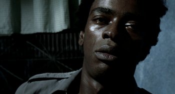 Movie still from “City of God” (2002), directed by Kátia Lund – A man's face in the dark; Close Up shot, High angle
