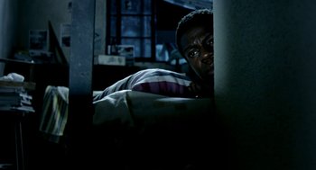 Movie still from “City of God” (2002), directed by Kátia Lund – A man is hiding in the corner of his bed; Medium shot, Overhead angle