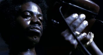 Movie still from “City of God” (2002), directed by Kátia Lund – A person with a microphone; Close Up shot, Low angle