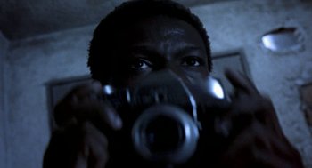 Movie still from “City of God” (2002), directed by Kátia Lund – A man taking a picture with a camera; Extreme Close Up shot, Low angle